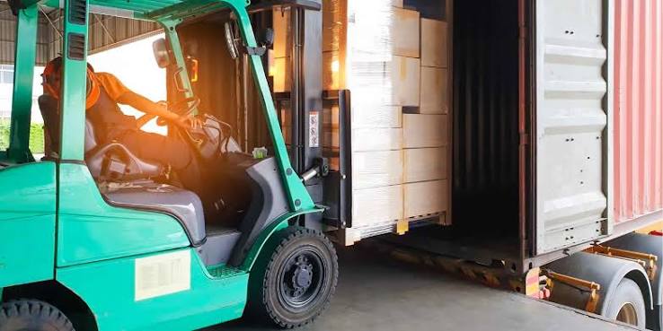 Chargement de matériel en conteneur avec chariot élévateur